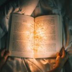 person holding string lights on opened book