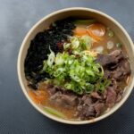 noodle soup with green leaf on white ceramic bowl